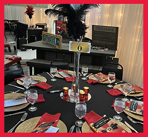 Table decorated with gold, black, and red for a banquet