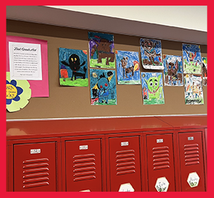 First grade artwork on wall above lockers